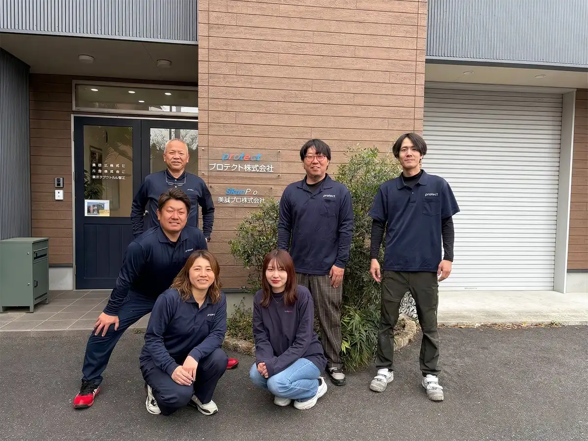 プロテクト株式会社のスタッフ集合写真（社屋前）